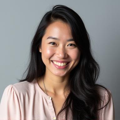 Professional headshot of female comedian Jenny Nguyen smiling.